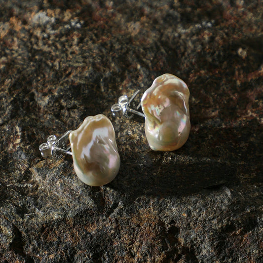 Pearl earrings on a dark stone surface