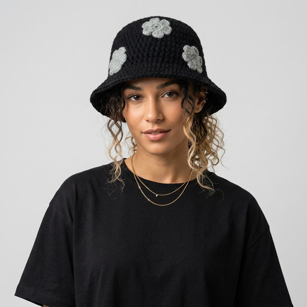 Woman wearing the black knitted bucket hat with grey flower appliqués