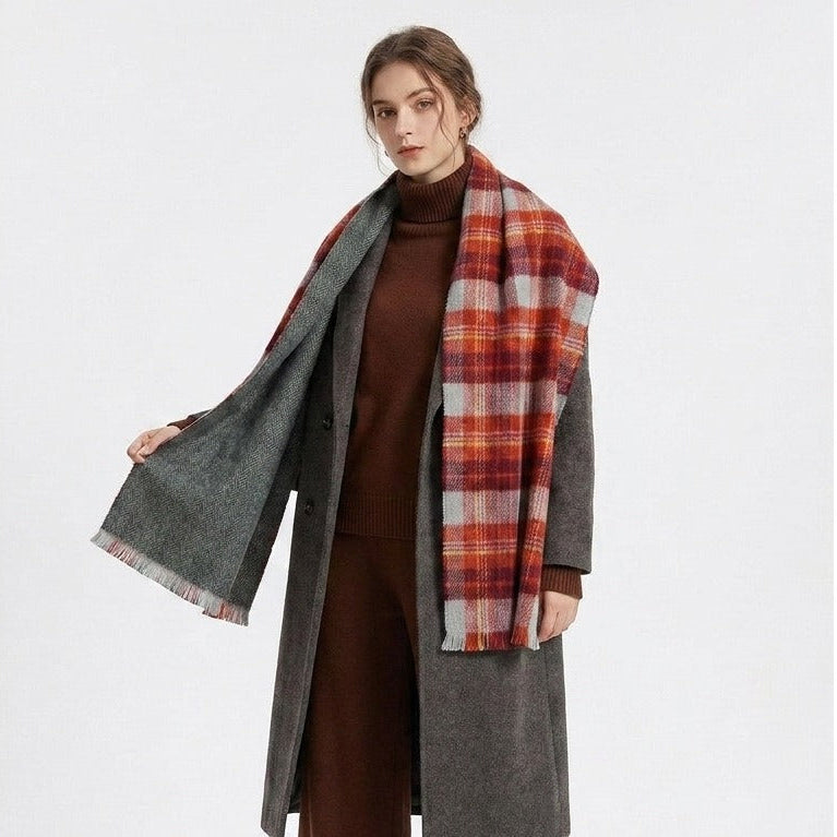 Woman wearing the red plaid scarf with its solid grey reverse over a long coat