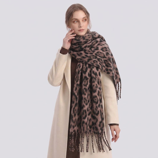 Woman in a cream coat wearing the leopard-print fringe scarf