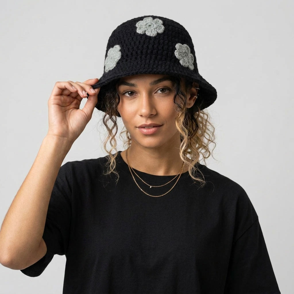 Woman touching the brim of the black floral knitted bucket hat