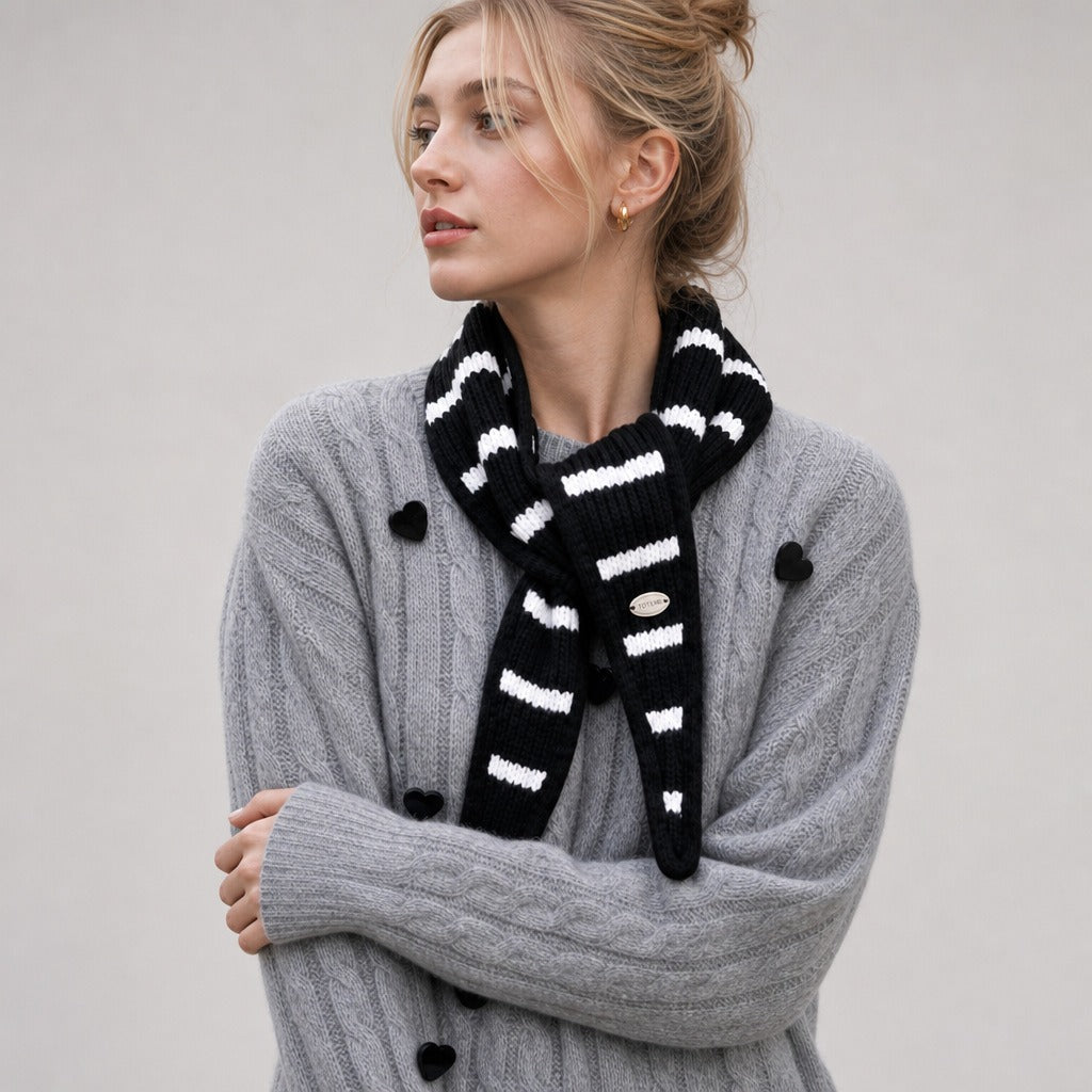 Woman looking sideways wearing the black and cream striped triangle scarf