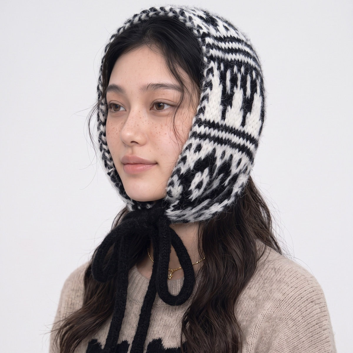Woman wearing the black and white Fair Isle knitted hood tied under the chin
