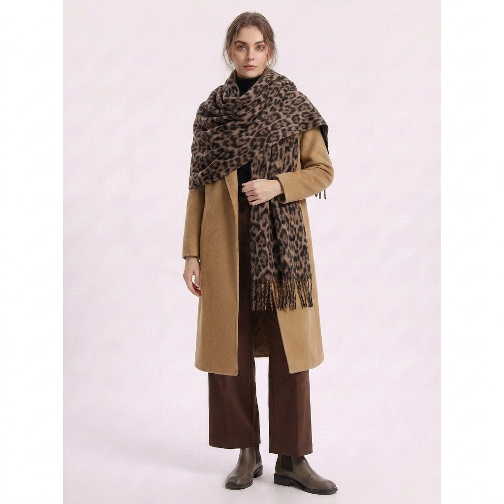 Woman holding the leopard-print scarf wrapped over a camel coat