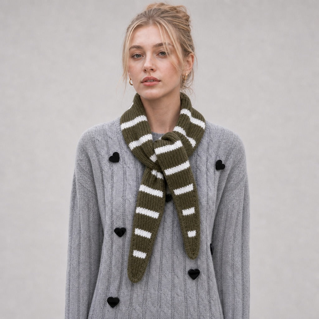 Woman wearing the army green striped triangle scarf knotted over a grey cardigan