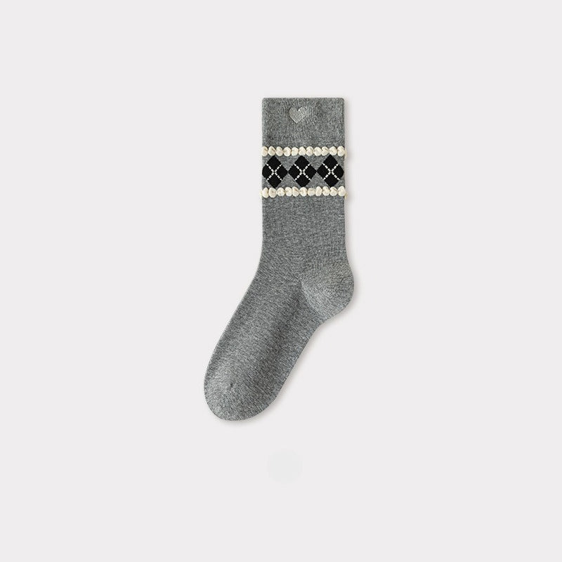 Grey crew sock with a black, white, and gold argyle pattern and a heart cutout at the cuff.