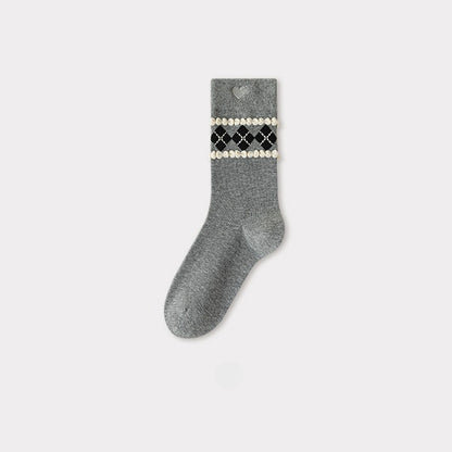 Grey crew sock with a black, white, and gold argyle pattern and a heart cutout at the cuff.