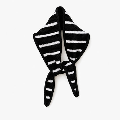 Black triangle scarf with cream stripes, knotted, on a white background