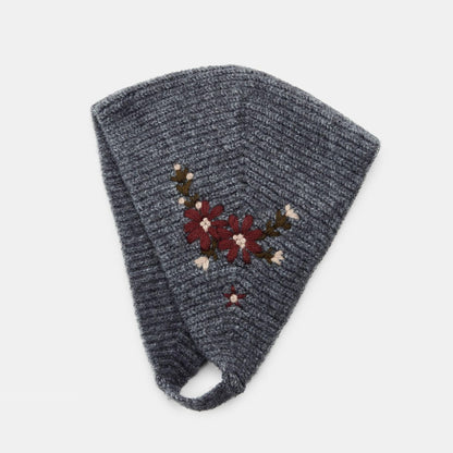 Grey knitted headscarf with red floral embroidery and chin strap, laid flat