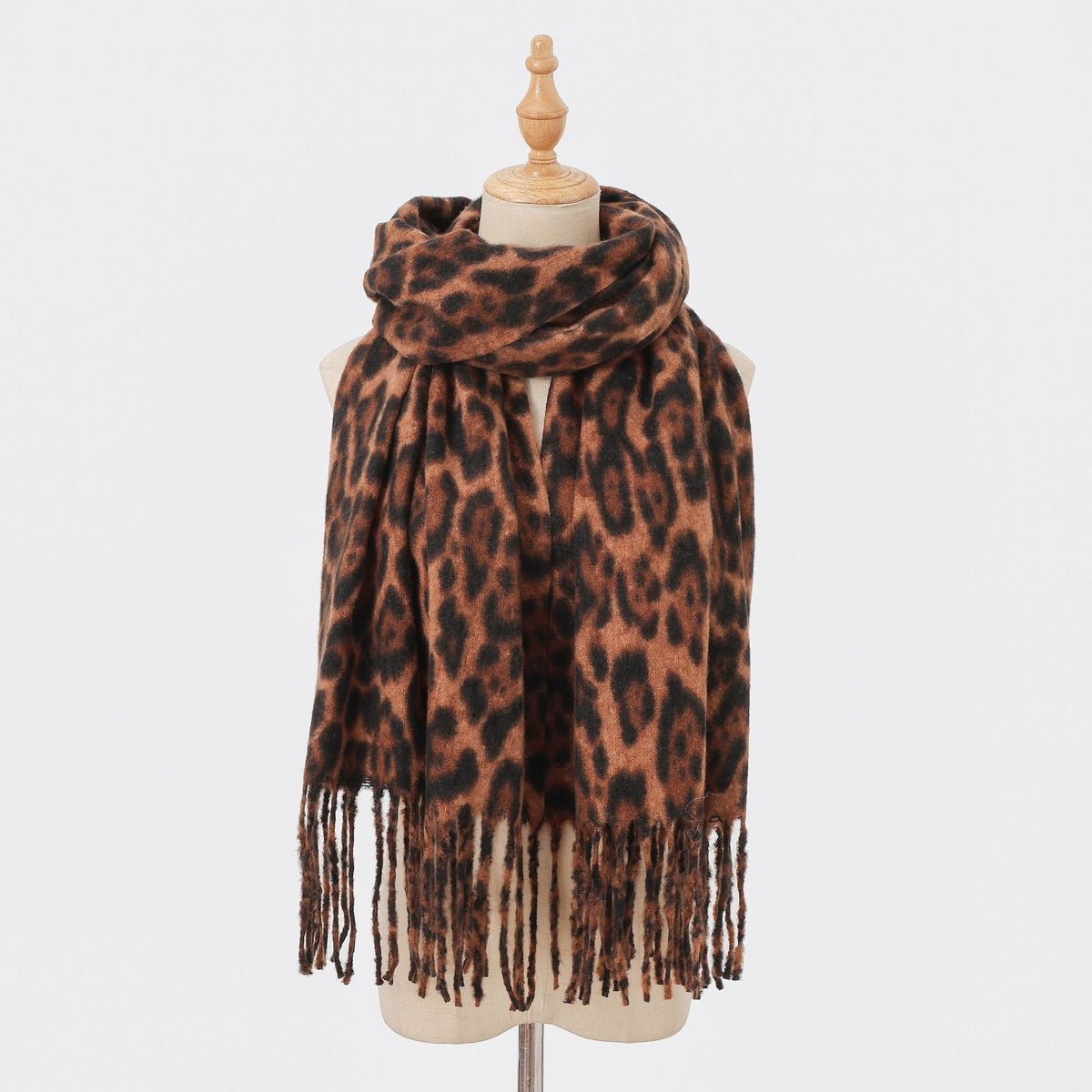 Classic brown leopard-print scarf with long fringe on a mannequin