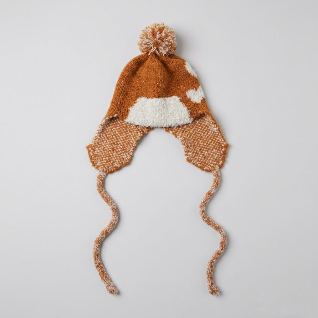 Bronze ear-flap hat with a cream heart pattern and pom-pom, laid flat