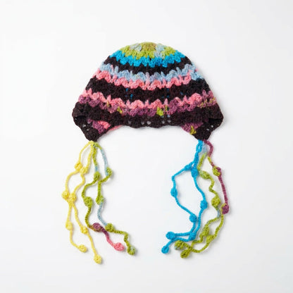 Pink and dark striped beanie with green and blue bobble strands, laid flat