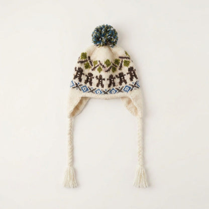 Cream gingerbread man ear-flap hat with green pom-pom and braided tassel ties, laid flat