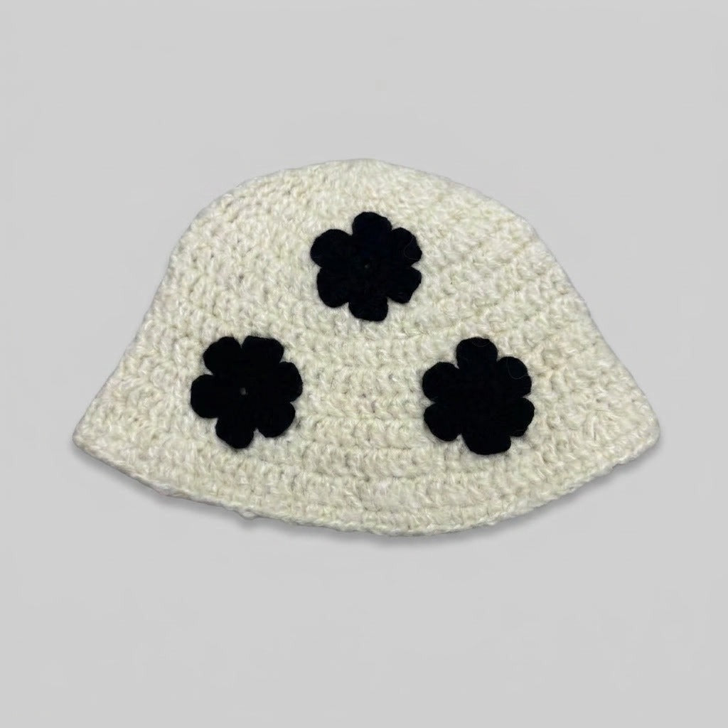 Cream knitted bucket hat with three black flower appliqués