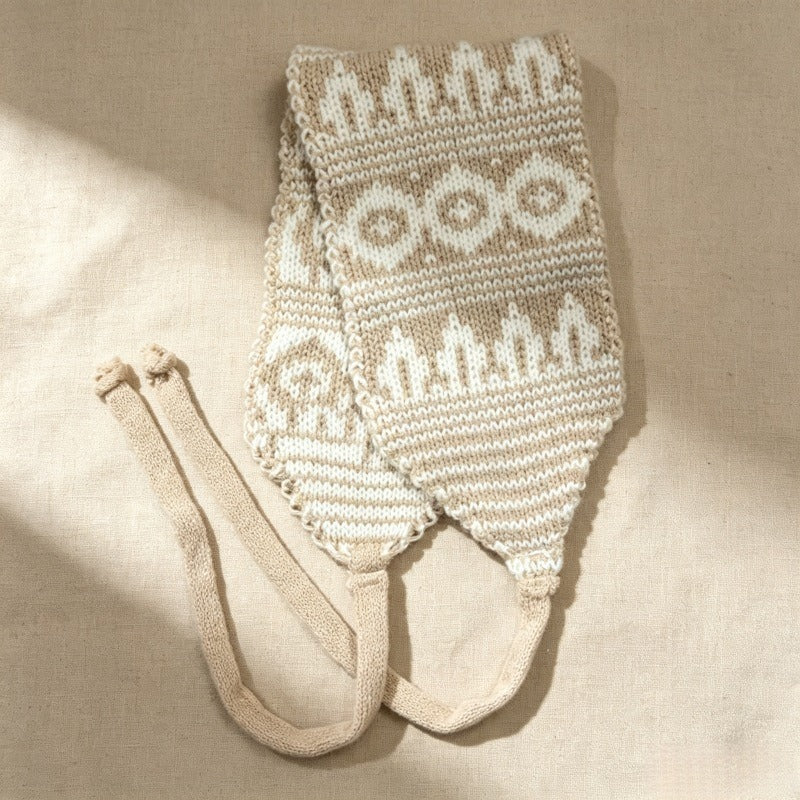 Camel and cream Fair Isle knitted hood laid flat in soft sunlight