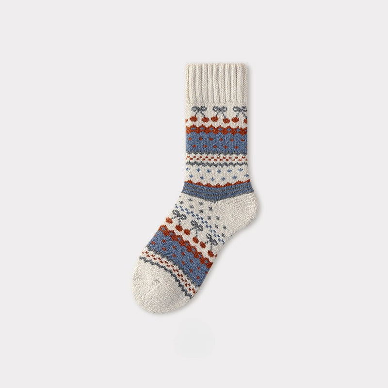 Single Nordic woolen sock with cream, blue, and rust traditional pattern.