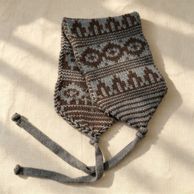 Grey and brown Fair Isle knitted hood laid flat with grey ties