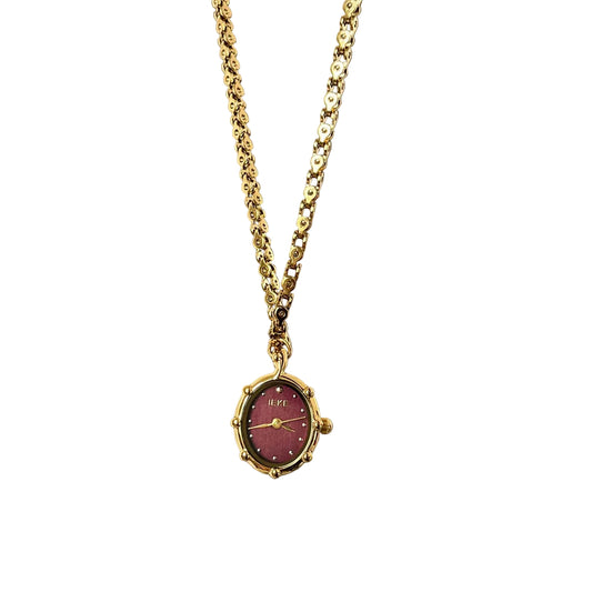 Gold oval pendant watch with a burgundy dial on a chunky chain