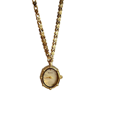 Gold oval pendant watch with a gold dial hanging from a chain