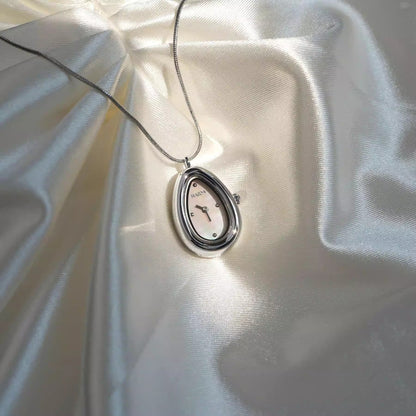 Silver teardrop necklace watch with a white dial on ivory satin