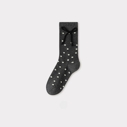 Charcoal gray crew socks with white polka dots and a black bow detail at the cuff.