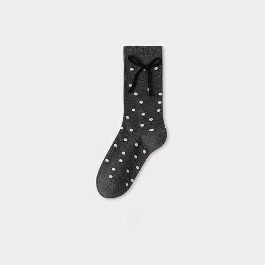 Charcoal gray crew socks with white polka dots and a black bow detail at the cuff.