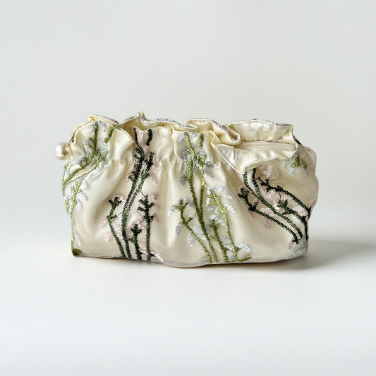 Cream embroidered makeup bag with green botanical embroidery and a gathered top