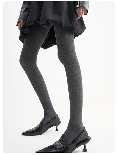 Sheer vertical-stripe tights in black, worn with a black skirt and slingback kitten heels