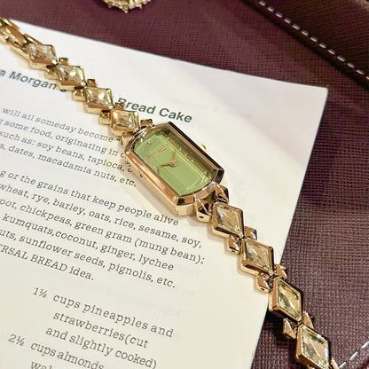 vintage women's gold-plated quartz jewelry watch featuring a barrel-shaped olive green dial and an interlocking rhombus link bracelet inlaid with faceted green crystals