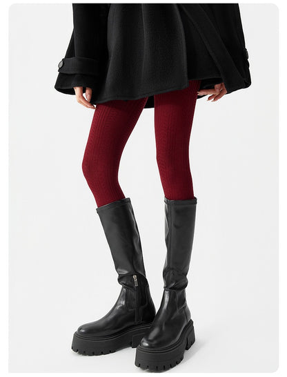 Women's knitted wool-blend winter tights in burgundy, worn with black knee-high boots