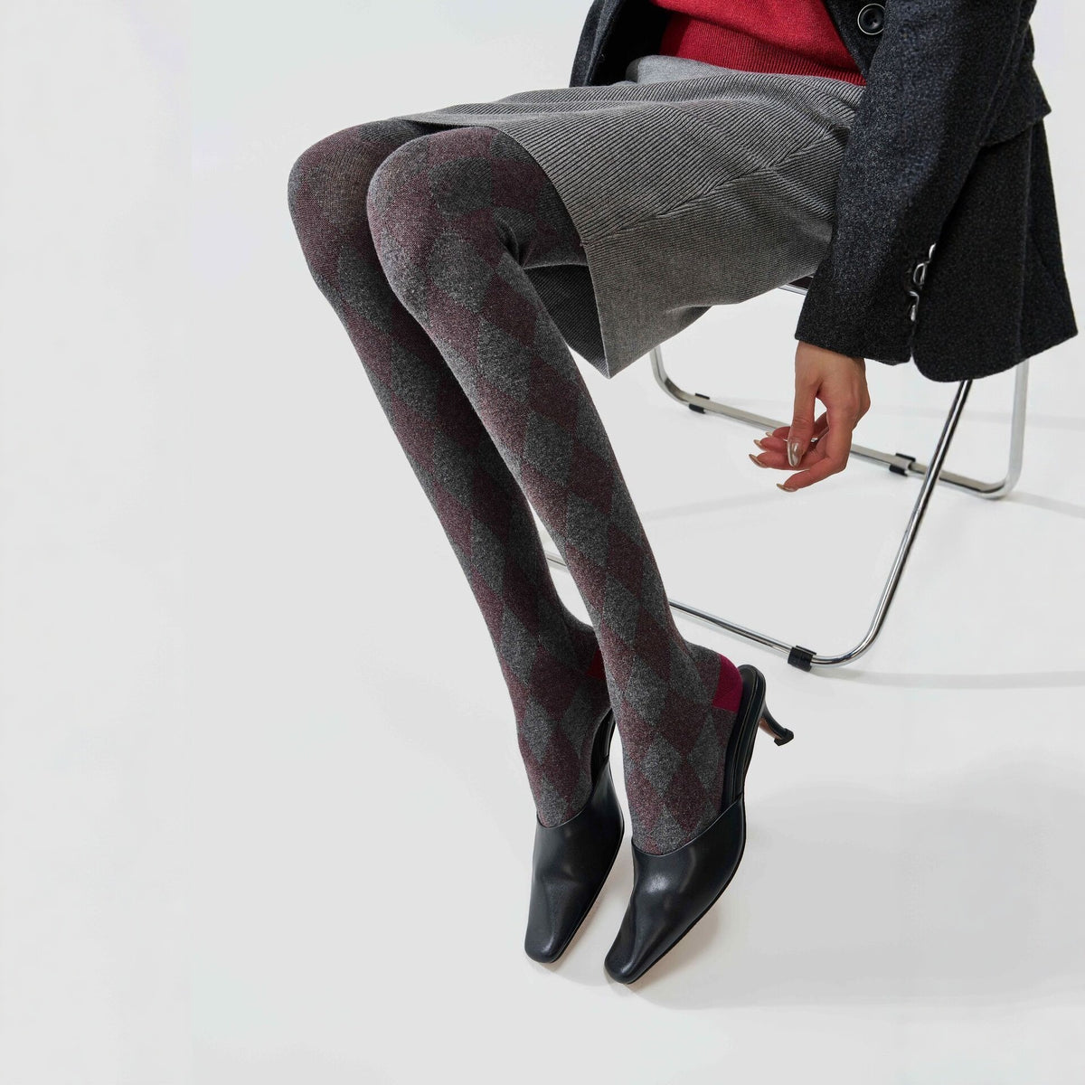 Women's tartan thermal tights in grey, seated side view showing the contrast heel