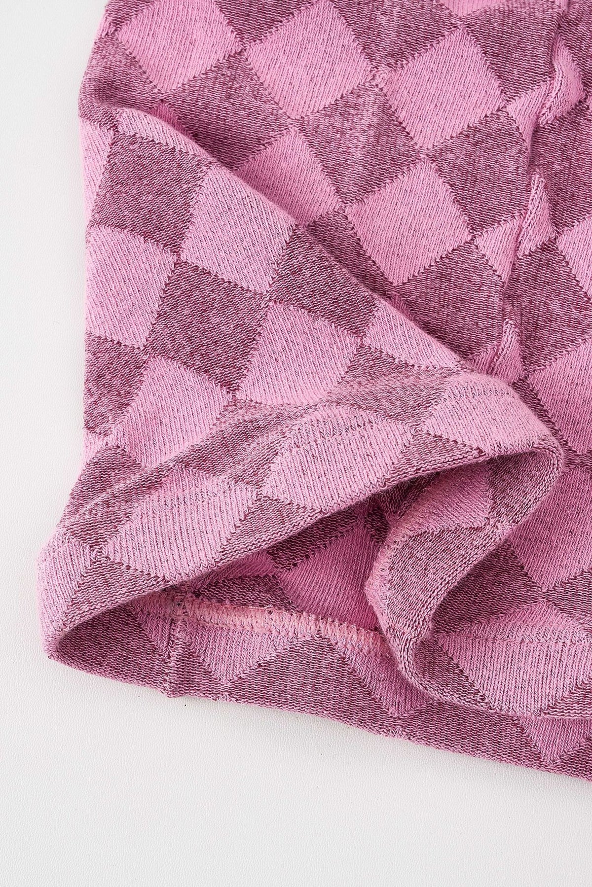 Close-up of pink tartan thermal tights showing the diamond check knit texture